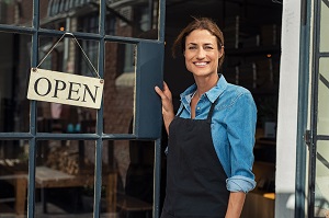 business owner standing outside open business