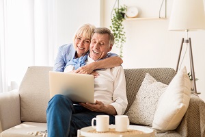 happy older couple smiling at laptop